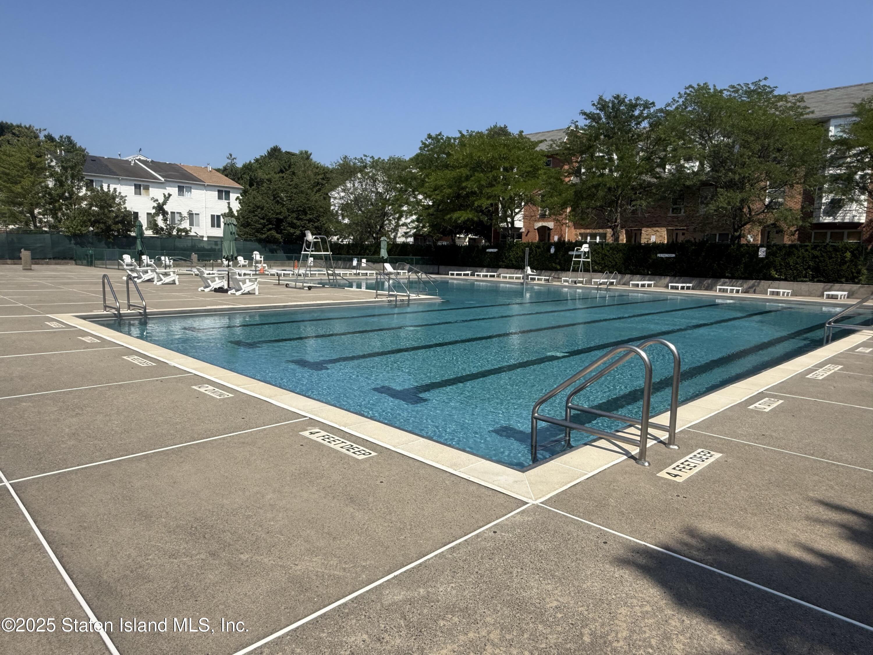 214 Ilyssa Way Staten Island, NY 10312 - Photo 14 of 22 a view of swimming pool with outdoor seating and trees in the background