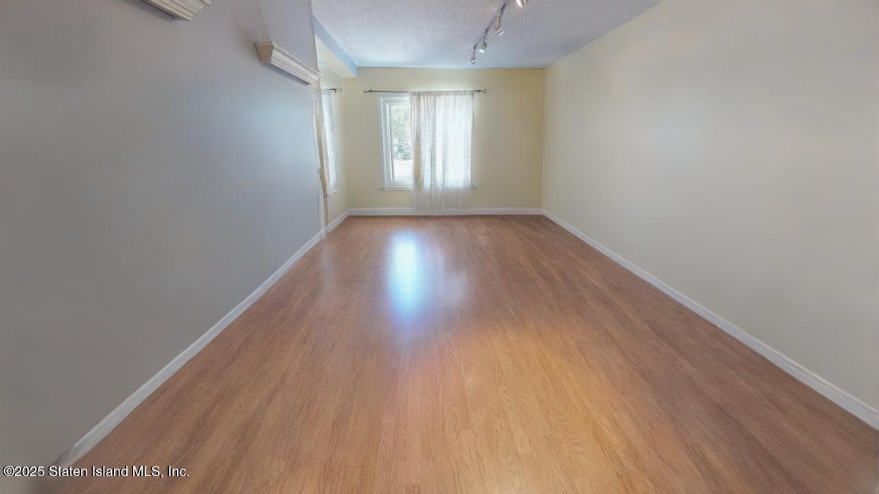 214 Ilyssa Way Staten Island, NY 10312 - Photo 3 of 22 an empty room with wooden floor and windows