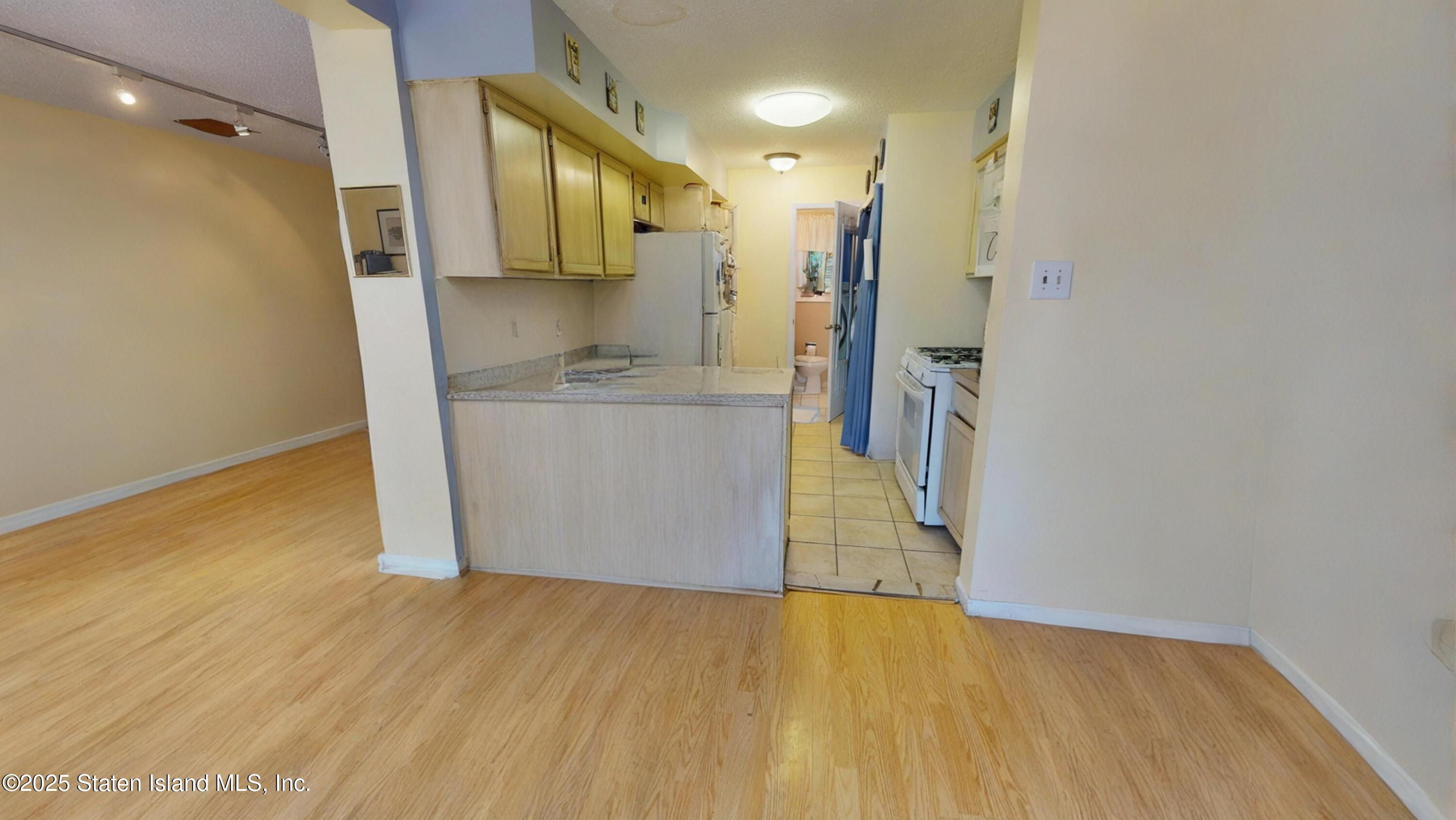 214 Ilyssa Way Staten Island, NY 10312 - Photo 9 of 22 a view of a kitchen cabinets and wooden floor