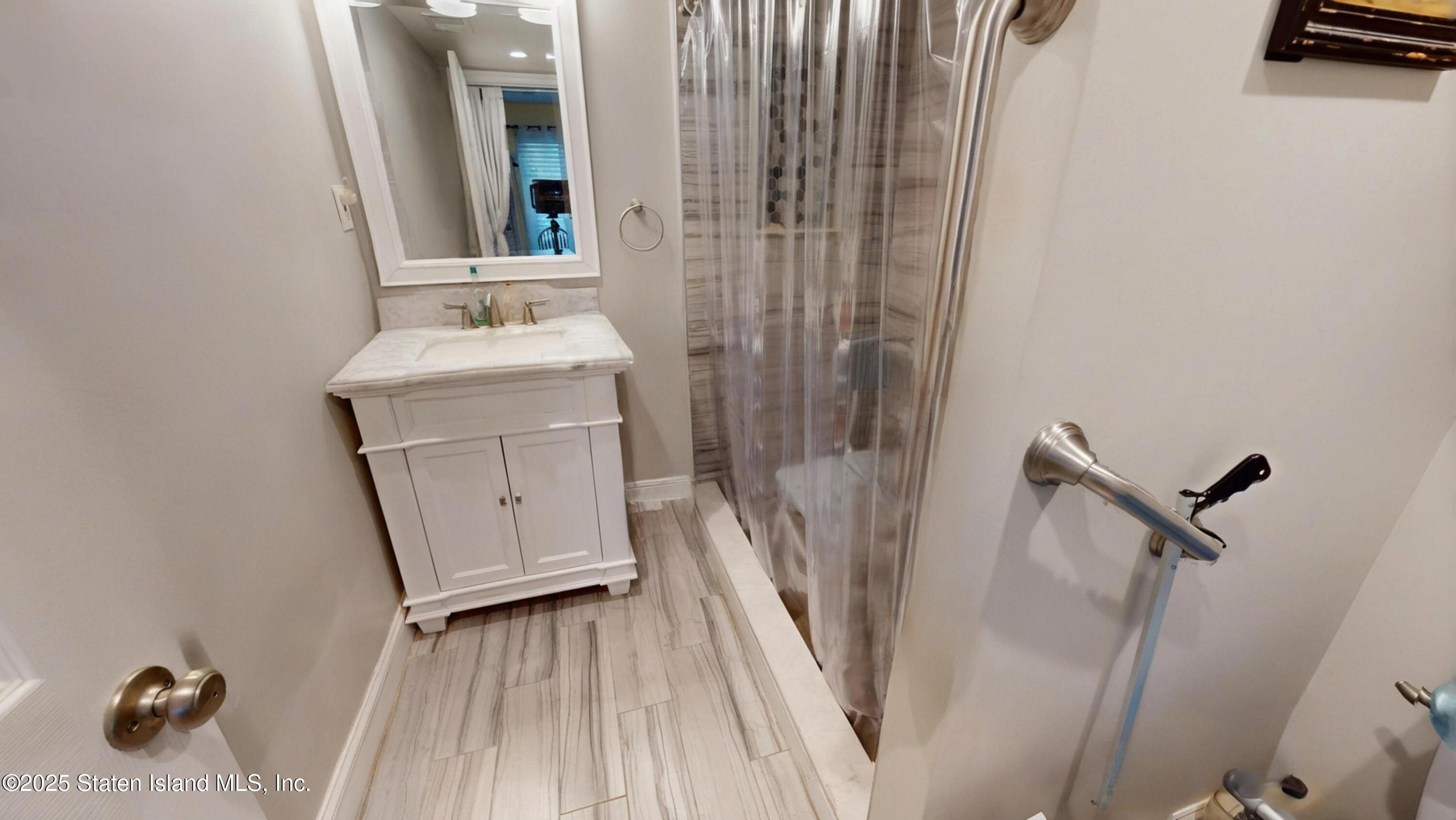 214 Ilyssa Way Staten Island, NY 10312 - Photo 10 of 22 a bathroom with a sink a mirror and shower