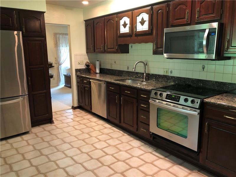 185 Overbrook Road Valencia, PA 16059 - Photo 4 of 25 Updated Eat in kitchen complete with quartz counter tops, stainless steel appliances, cherry-wood cabinets, double sink, and ceramic tile floor. Large Bay window looks out to the back patio/yard.