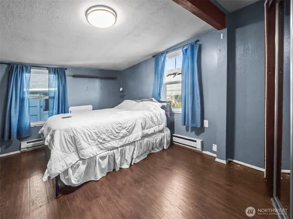 an empty room with wooden floor and window
