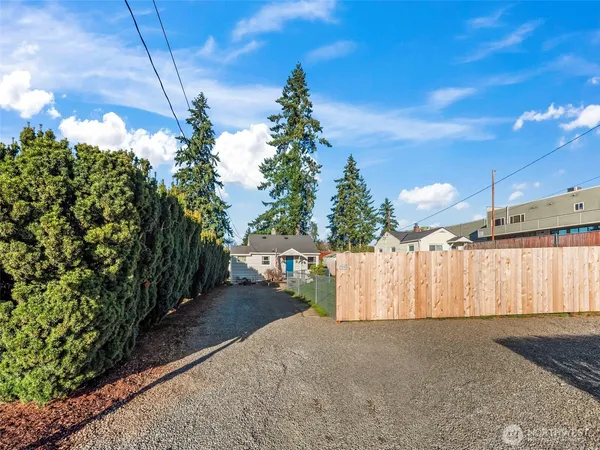a view of a house with a yard and large tree