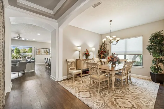 a dining room with furniture a chandelier and wooden floor