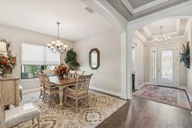 a view of a dining room with furniture and chandelier