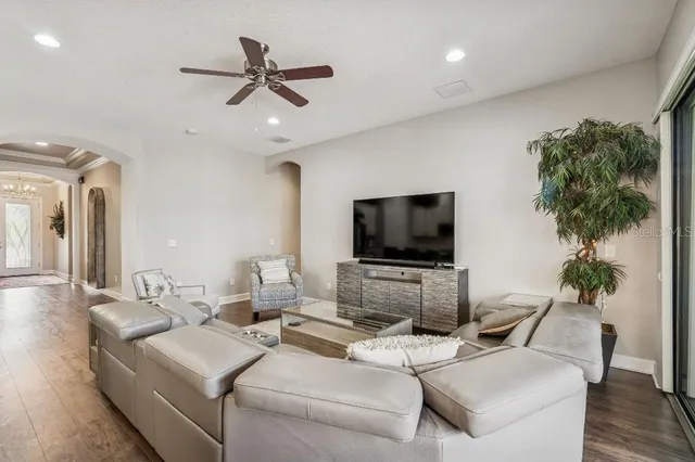 a living room with furniture kitchen view and a chandelier