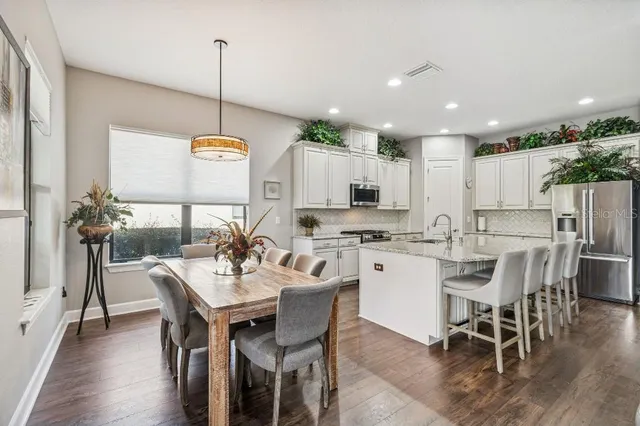 a kitchen with stainless steel appliances kitchen island granite countertop a sink dishwasher and a flat screen tv