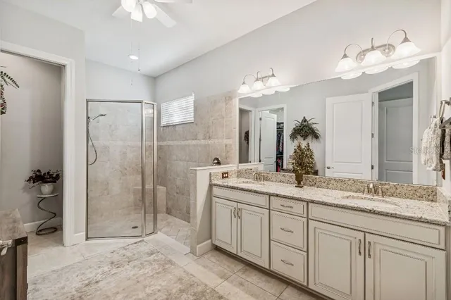 a bathroom with a double vanity sink a mirror and shower
