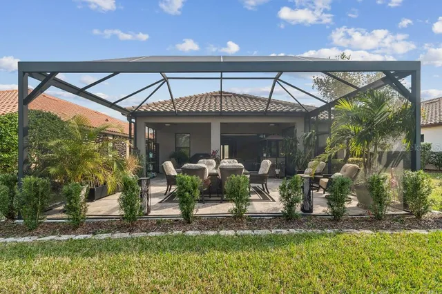 a view of a house with backyard and sitting area