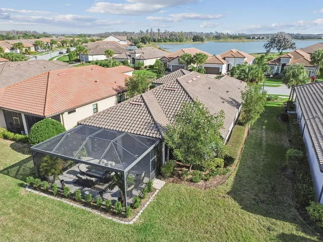 an aerial view of a house with a yard and lake view