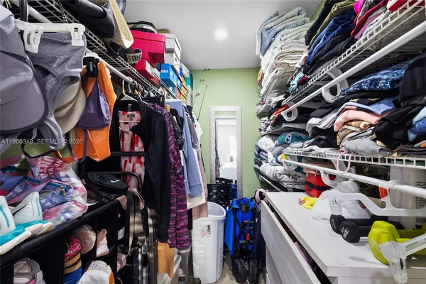 a view of walk in closet with clothes and shoes