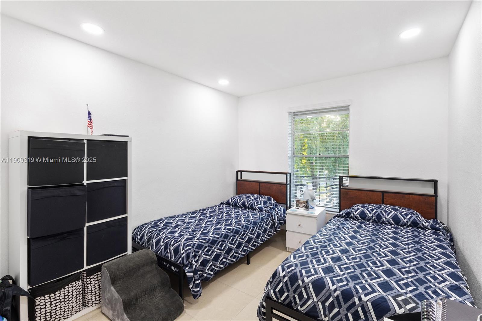 5665 West 20th Avenue, Unit 212 Hialeah, FL 33012 - Photo 17 of 38 a bedroom with bed and a window