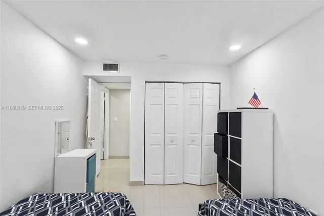 a kitchen with a refrigerator and white cabinets