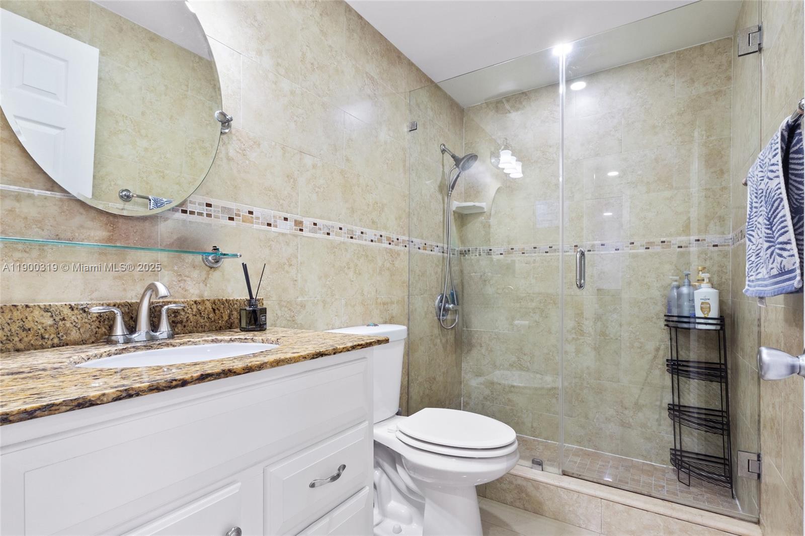 5665 West 20th Avenue, Unit 212 Hialeah, FL 33012 - Photo 19 of 38 a bathroom with a granite countertop sink mirror toilet and shower