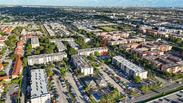 an aerial view of a city with lots of residential buildings ocean and mountain view in back
