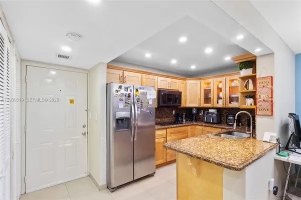 a kitchen with stainless steel appliances granite countertop a refrigerator and a sink