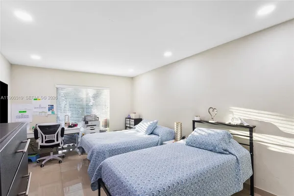 a bedroom with two beds and a desk