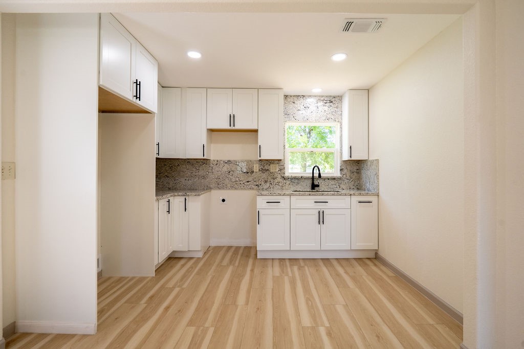 58 Hybiscus Court Lake Jackson, TX 77566 - Photo 3 of 21 a kitchen with granite countertop white cabinets and white appliances