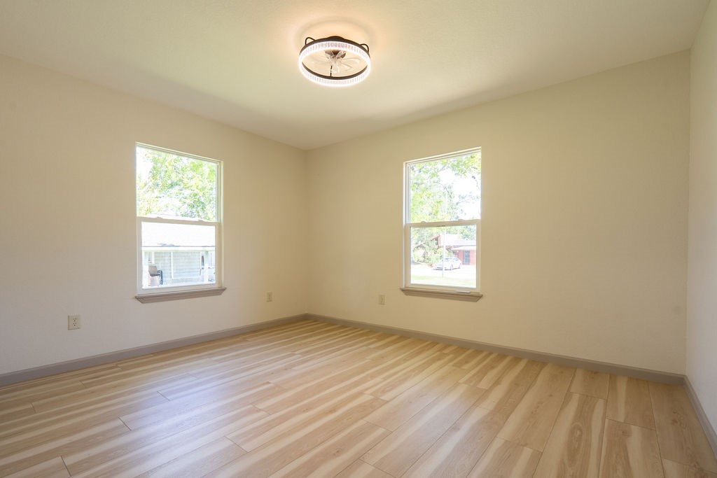 58 Hybiscus Court Lake Jackson, TX 77566 - Photo 5 of 21 a view of an empty room with wooden floor and a window