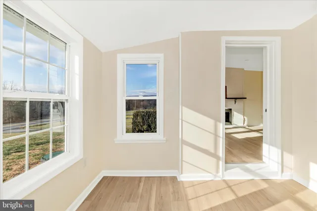 wooden floor fireplace and windows in an empty room