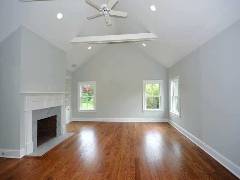 569 Middlesex Road Darien, CT 06820 - Photo 16 of 25 an empty room with wooden floor fireplace and windows