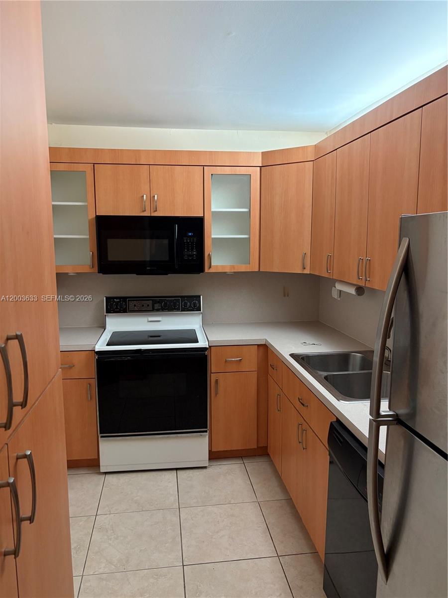 8335 Southwest 72nd Avenue, Unit 108D Miami, FL 33143 - Photo 3 of 20 a kitchen with stainless steel appliances a refrigerator and a stove top oven