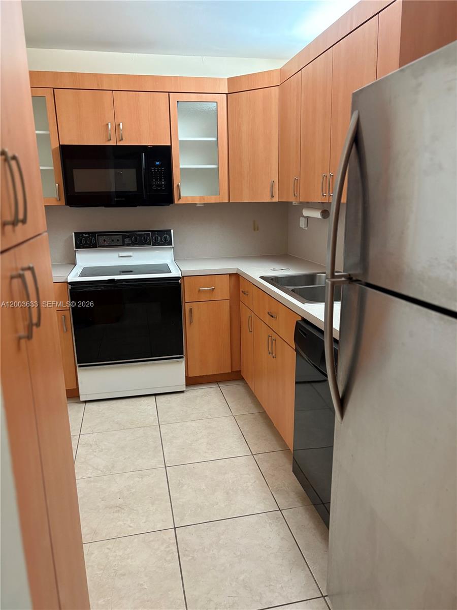 8335 Southwest 72nd Avenue, Unit 108D Miami, FL 33143 - Photo 4 of 20 a kitchen with stainless steel appliances a stove a microwave and a refrigerator