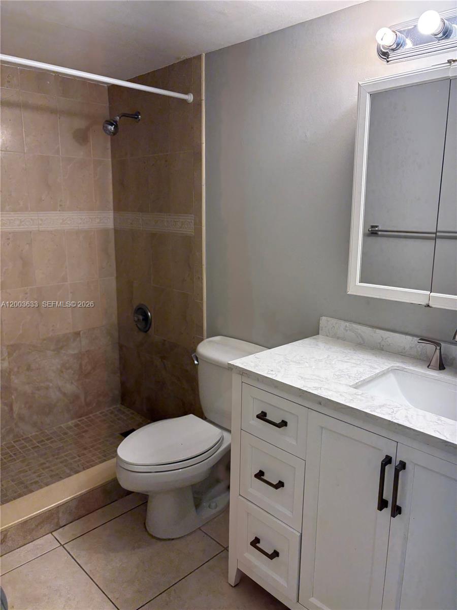 8335 Southwest 72nd Avenue, Unit 108D Miami, FL 33143 - Photo 8 of 20 a bathroom with a granite countertop toilet sink and shower