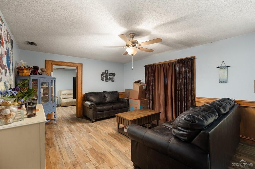 251 Delmita Road Delmita, TX 78536 - Photo 2 of 13 Living room with ceiling fan, a textured ceiling, and light hardwood / wood-style flooring