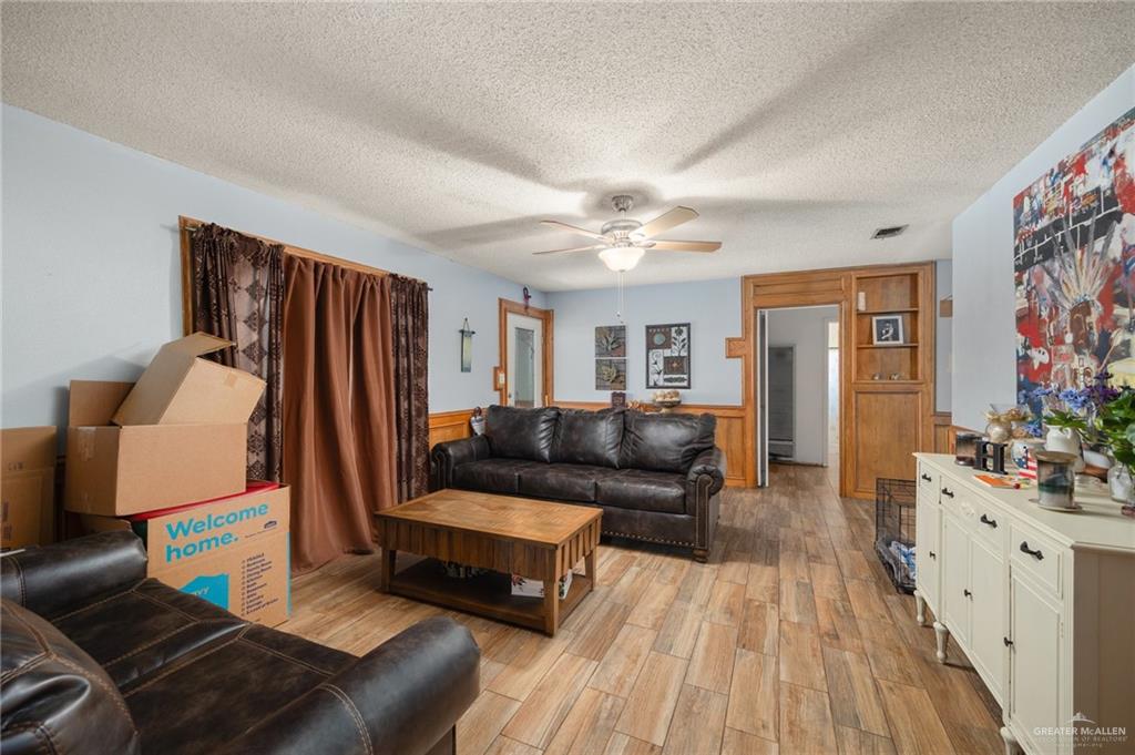 251 Delmita Road Delmita, TX 78536 - Photo 3 of 13 Living room featuring light hardwood / wood-style floors, a textured ceiling, and ceiling fan
