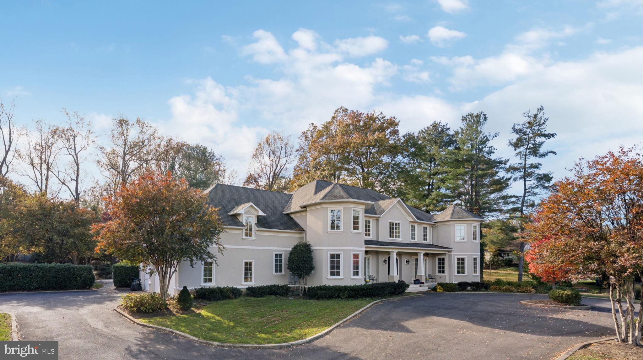 a front view of a house with a garden and trees