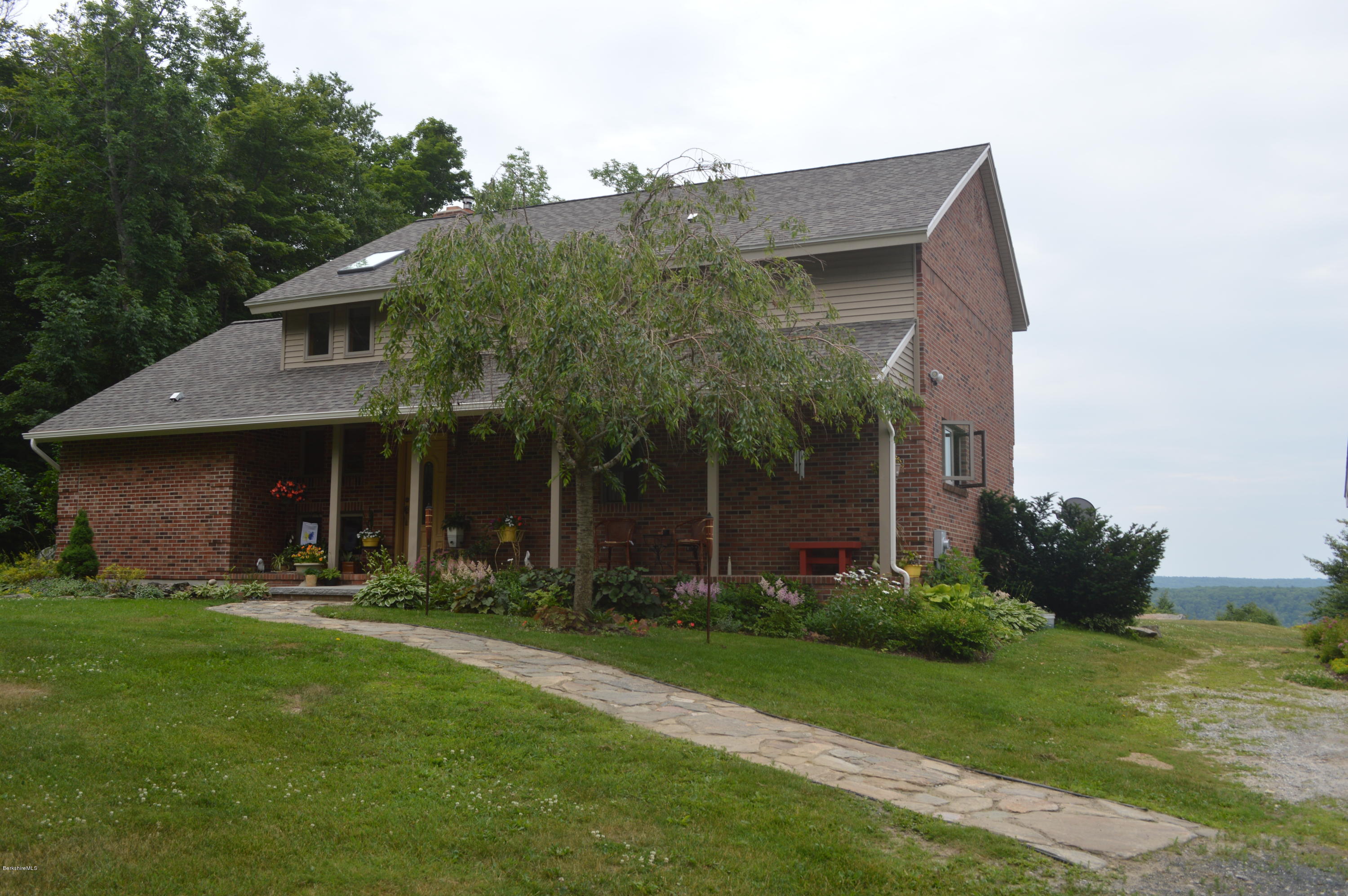 759 George Carter Road Becket, MA 01223 - Photo 2 of 56 a front view of a house with garden