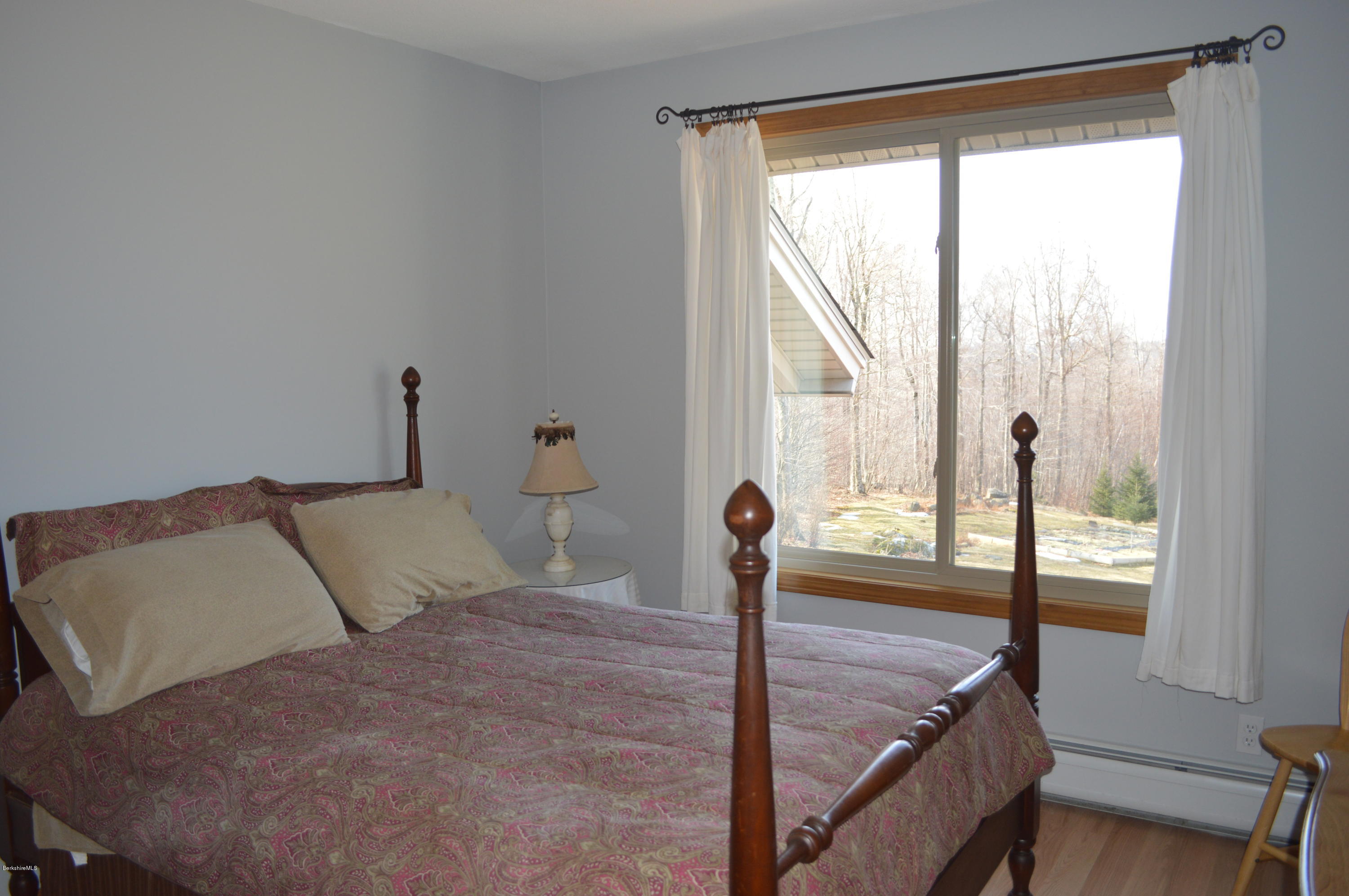 759 George Carter Road Becket, MA 01223 - Photo 16 of 56 a bed sitting in a bedroom next to a window