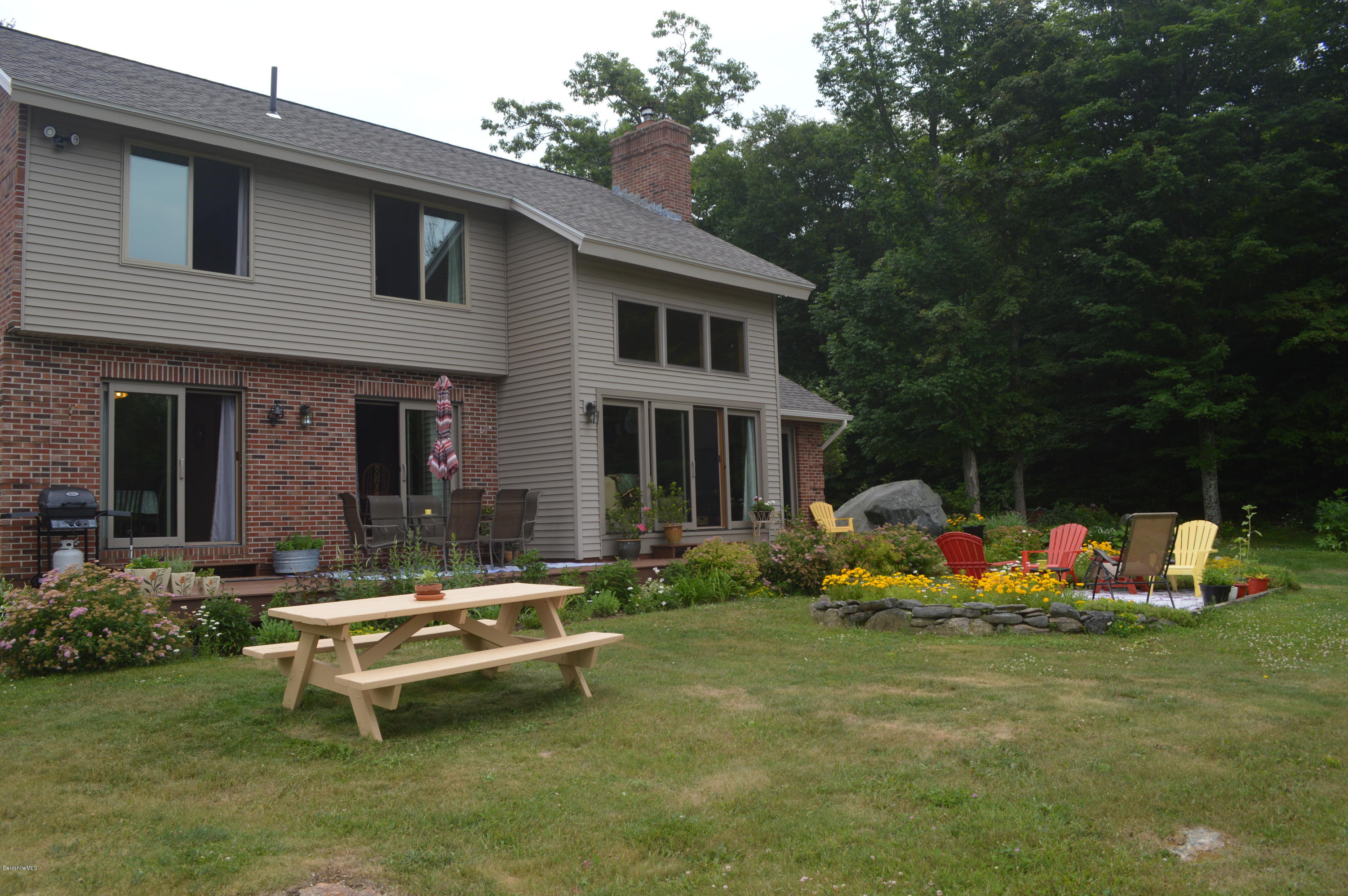 759 George Carter Road Becket, MA 01223 - Photo 45 of 56 a view of a house with backyard sitting area and garden