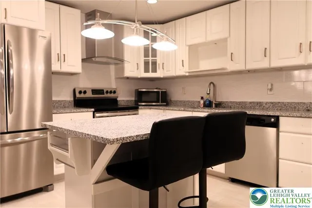 a kitchen with stainless steel appliances granite countertop a sink refrigerator and cabinets