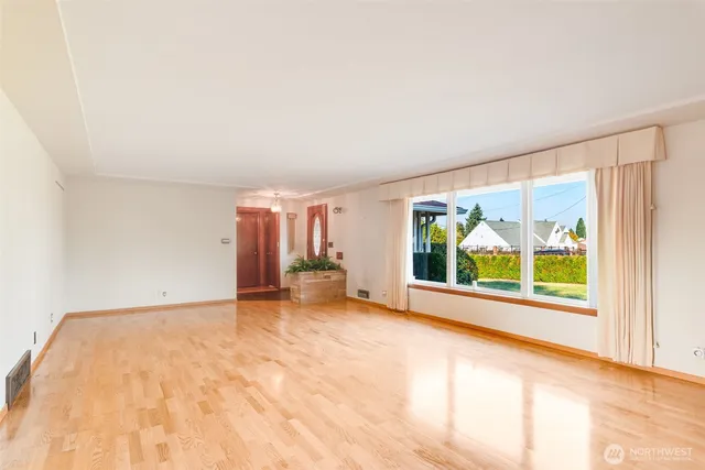 a view of an empty room with a fireplace and a window
