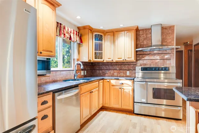 a kitchen with stainless steel appliances granite countertop a refrigerator and a sink