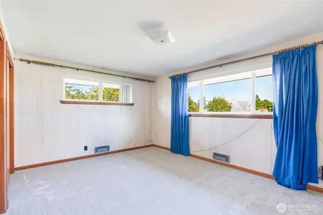 a bedroom with a bed and a large window