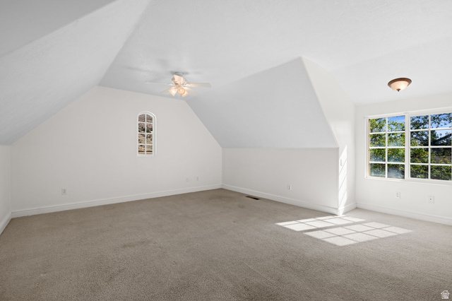 20 Valley Road Leeds, UT 84746 - Photo 23 of 57 Spacious room featuring sloped ceilings, a large multi-pane window, an arched multi-pane window, neutral carpeting, and a ceiling fan