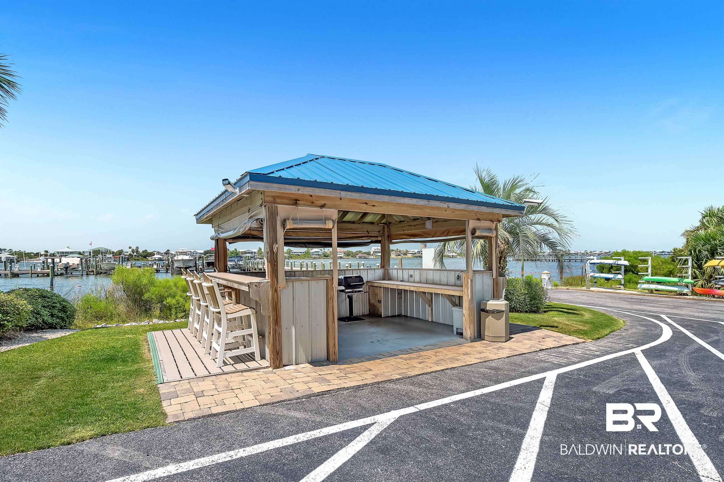 16287 Perdido Key Drive, Unit 105 Pensacola, FL 32507 - Photo 48 of 66 Waterfront covered outdoor entertaining space featuring a built-in bar, integrated grill, and ample counter space, set on a paver and composite deck surface