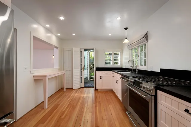 a large kitchen with stainless steel appliances granite countertop a stove and a sink