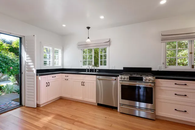 a kitchen with a stove a sink and a window