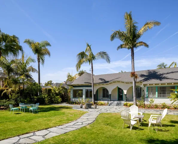 a view of a swimming pool with a table and chairs under an umbrella