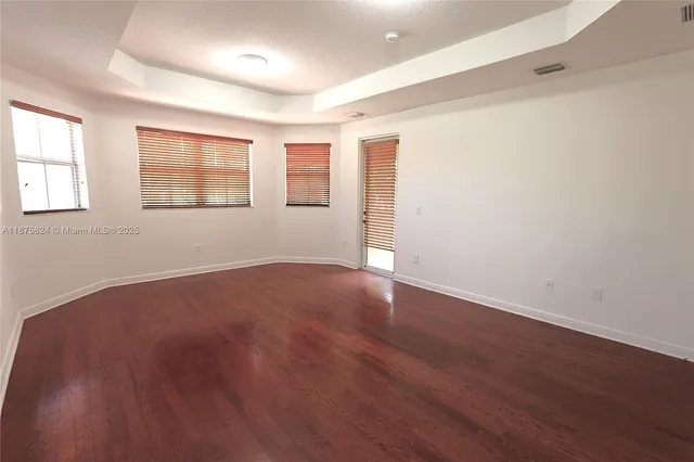 a view of empty room with wooden floor