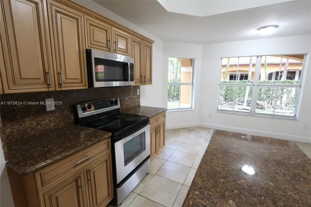 a kitchen with stainless steel appliances granite countertop a stove microwave and sink