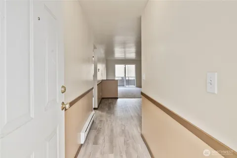 a view of a hallway with wooden floor and staircase
