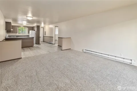 a view of a kitchen with refrigerator and white cabinets