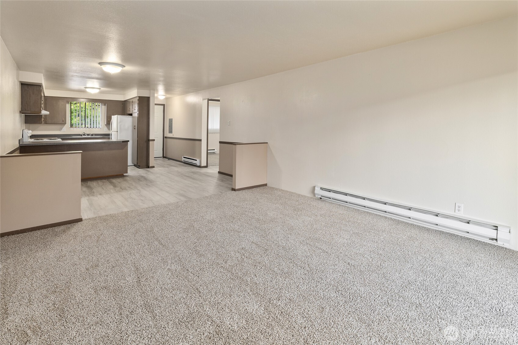 2517 Howard Avenue Everett, WA 98203 - Photo 4 of 32 a view of a kitchen with refrigerator and white cabinets