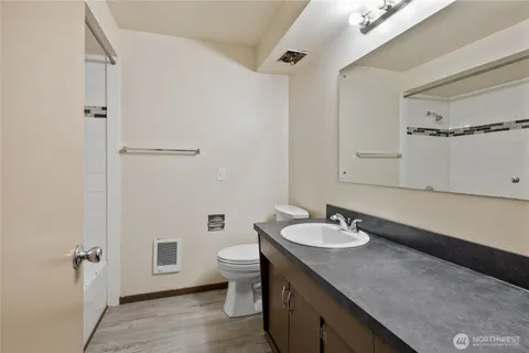 a bathroom with a sink a toilet and shower