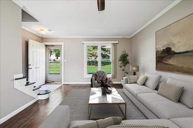 938 Cardiff Court, Unit 938 Schaumburg, IL 60169 - Photo 2 of 3 a living room with furniture and large windows